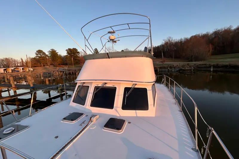 Slide: The Image of 2004 PDQ 34 Power Catamaran docked at sunset, featuring spacious deck and sleek design. - 7