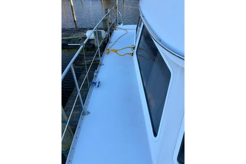 Slide: The Image of 2004 PDQ 34 Power Catamaran deck view with railing and docked at marina. - 9