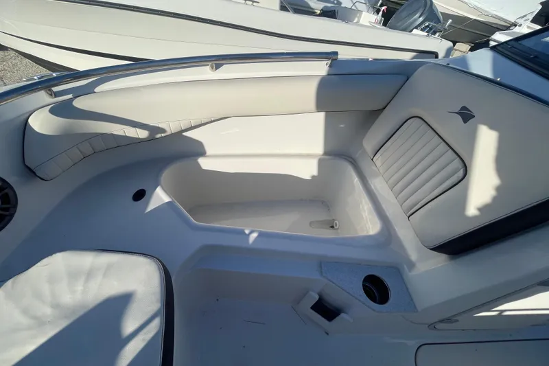 Slide: The Image of 2021 Stingray 201 DC boat interior with seating and storage area. - 11