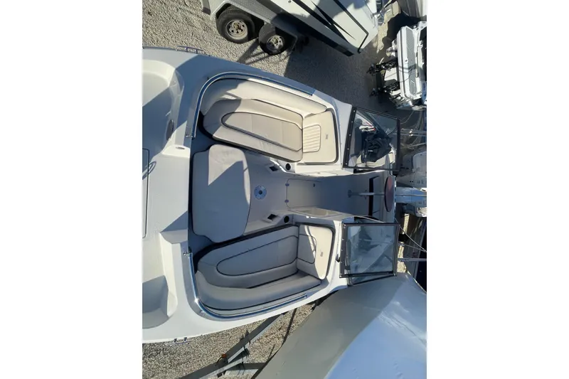 Slide: The Image of 2021 Stingray 201 DC boat interior with beige seating and open cockpit view. - 15