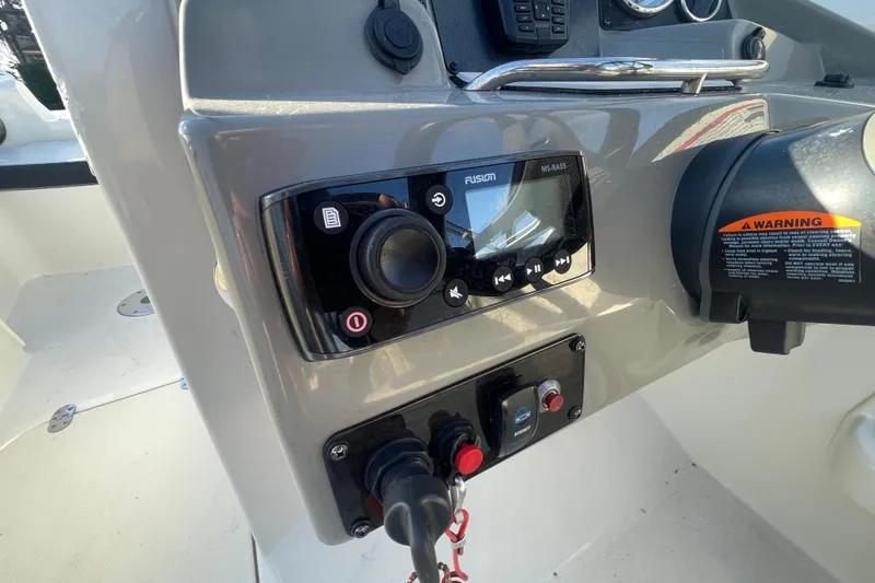 Slide: The Image of Control panel of a 2021 Stingray 201 DC boat with audio system and warning label. - 18