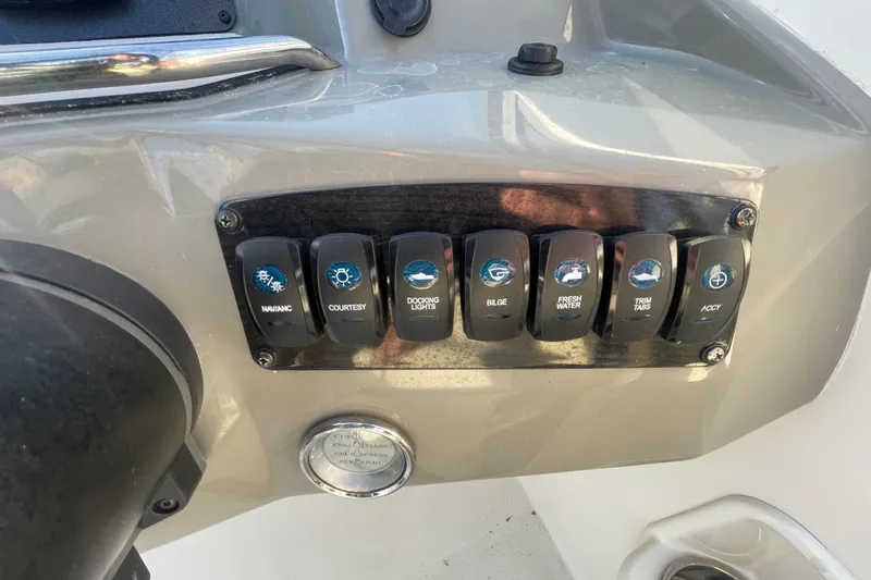 Slide: The Image of Control panel of a 2021 Stingray 201 DC boat with labeled switches. - 23