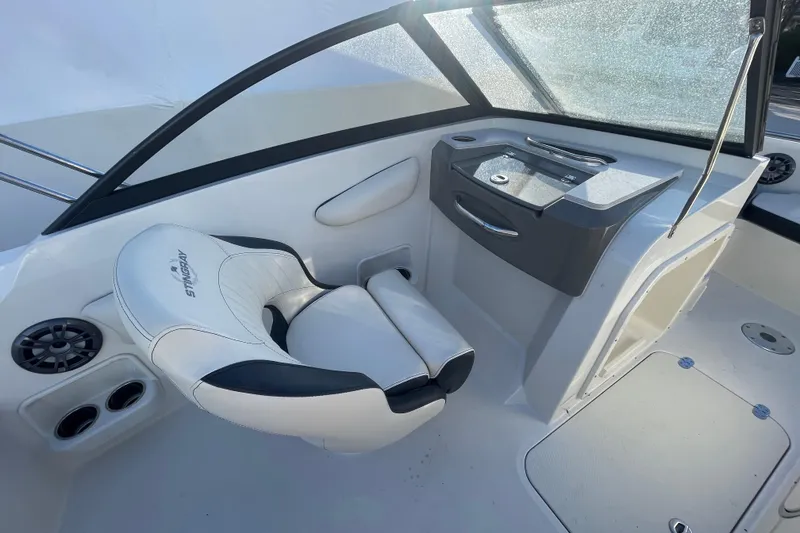 Slide: The Image of 2021 Stingray 201 DC boat interior with white seating and dashboard. - 24