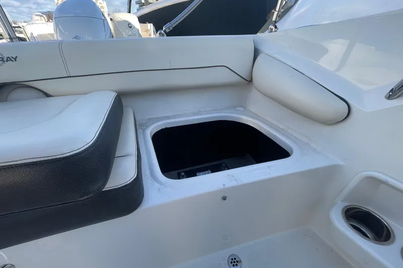 Slide: The Image of 2021 Stingray 201 DC boat interior with open storage compartment and cushioned seating. - 29