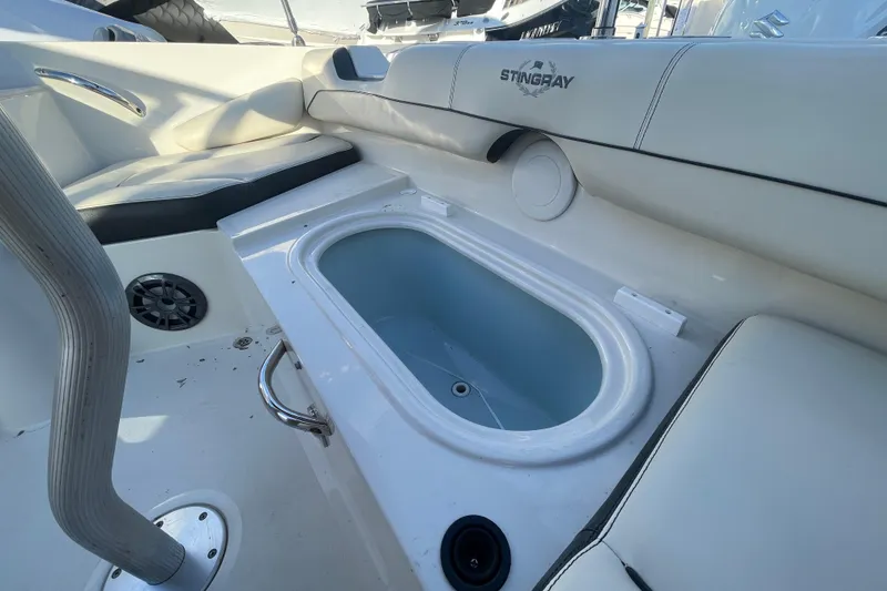 Slide: The Image of 2021 Stingray 201 DC boat interior with seating and built-in storage compartment. - 30