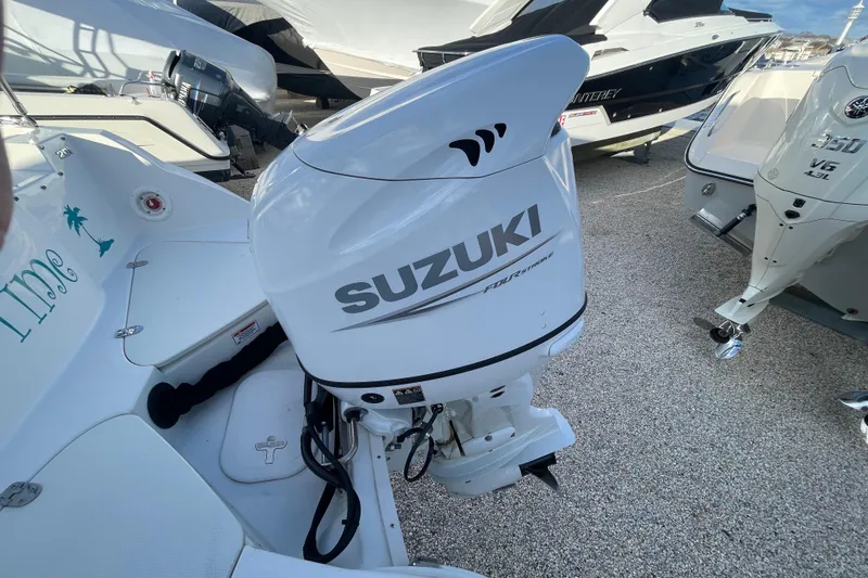 Slide: The Image of 2021 Stingray 201 DC boat with Suzuki outboard motor in a marina setting. - 35