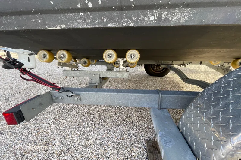 Slide: The Image of Trailer rollers under a 2021 Stingray 201 DC boat on gravel surface. - 41