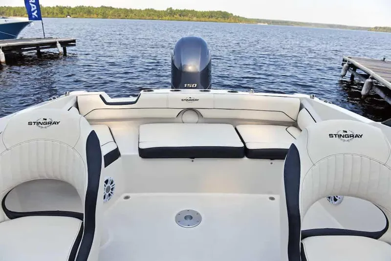 Slide: The Image of 2021 Stingray 201 DC boat with 140 HP engine, parked on gravel. - 6