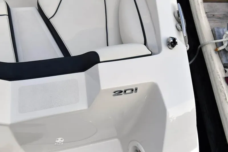 Slide: The Image of 2021 Stingray 201 DC boat interior with seating, table, and canopy in a marina setting. - 7