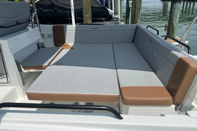 Slide: The Image of 2024 Beneteau Flyer 9 SUNdeck boat seating area with gray and brown cushions. - 13