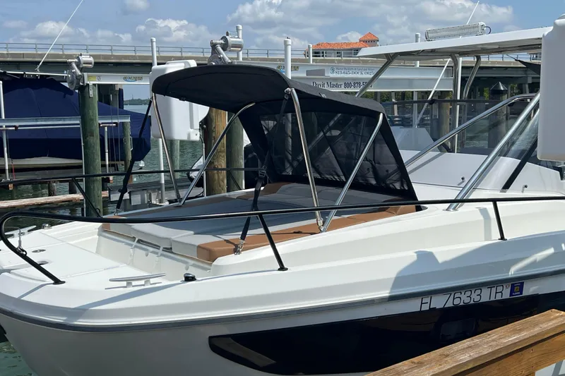 Slide: The Image of 2024 Beneteau Flyer 9 SUNdeck boat docked, featuring sleek design and sunshade canopy. - 2