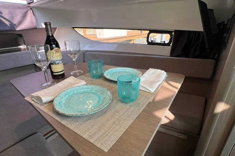 Slide: The Image of Interior dining setup on 2024 Beneteau Flyer 9 SUNdeck with wine and turquoise tableware. - 24