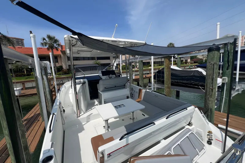 Slide: The Image of 2024 Beneteau Flyer 9 SUNdeck boat docked, featuring spacious seating and modern design. - 7