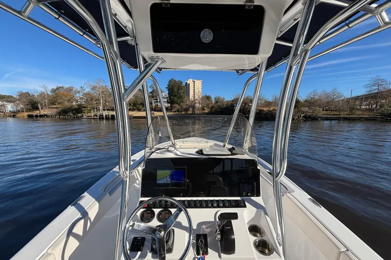 Slide: The Image of 2024 Sea Hunt Ultra 219 boat dashboard with steering wheel and navigation system. - 2