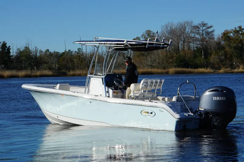 Slide: The Image of 2024 Sea Hunt Ultra 219 boat on calm water with Yamaha engine. - 8