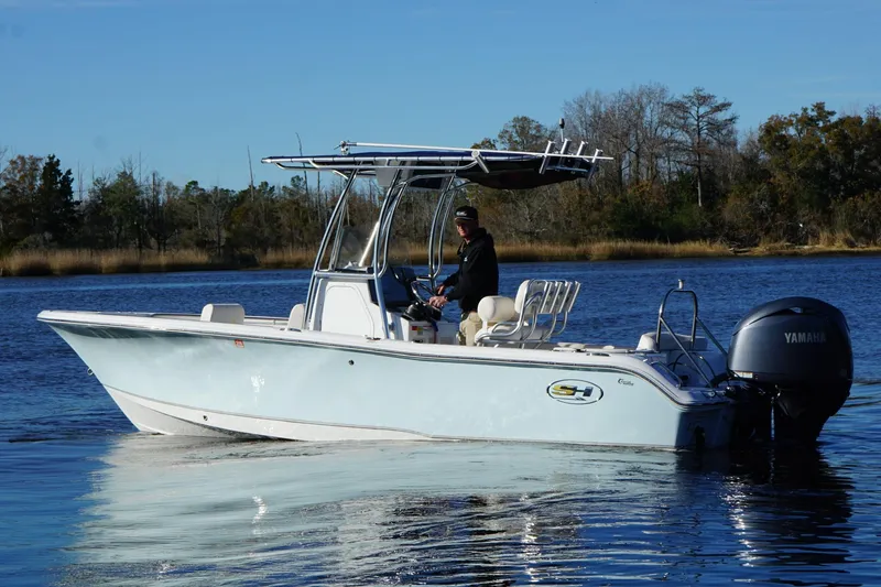 Slide: The Image of 2024 Sea Hunt Ultra 219 boat cruising on a calm lake with a Yamaha engine. - 9