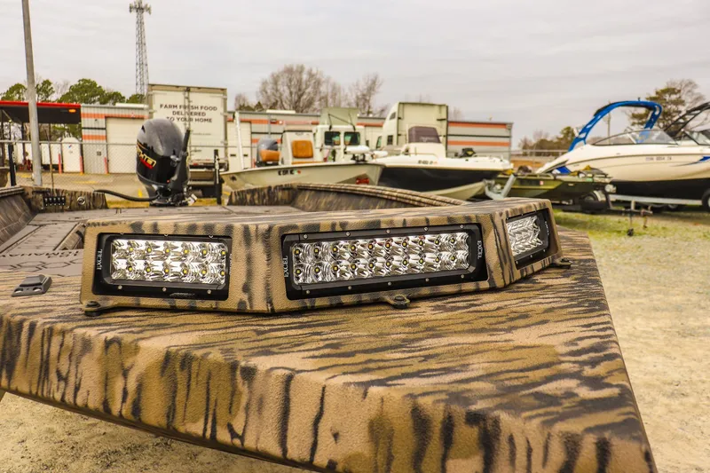 Slide: The Image of 2026 Excel Tomahawk boat with camouflage design and LED lights, parked outdoors. - 11