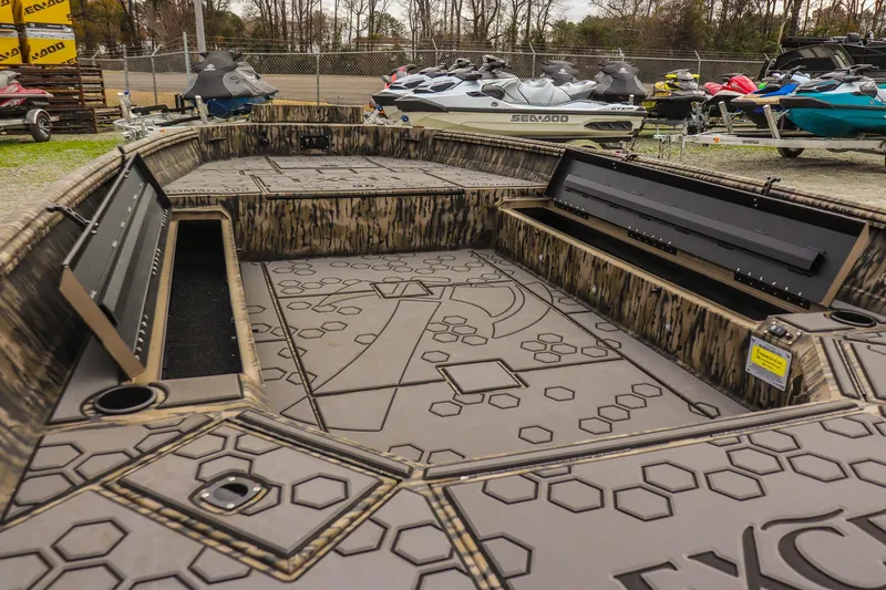 Slide: The Image of 2026 Excel Tomahawk boat interior with storage compartments and hexagonal pattern design. - 13