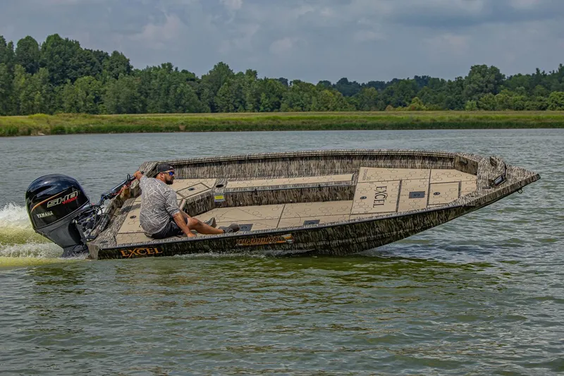 Slide: The Image of Manufacturer Provided Image: 2026 Excel Tomahawk boat cruising on a lake with lush green trees in the background. - 17