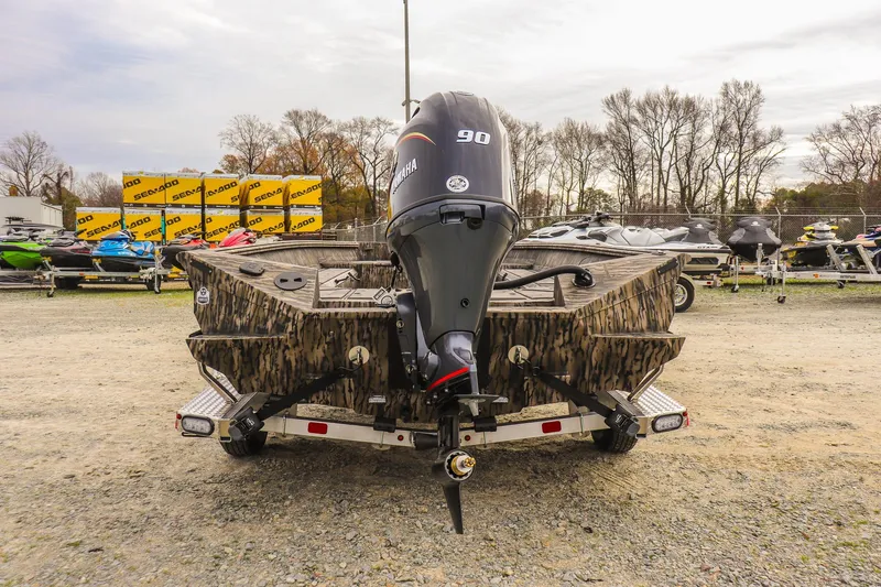Slide: The Image of 2026 Excel Tomahawk boat with Yamaha 90 engine, camo design, parked outdoors. - 3