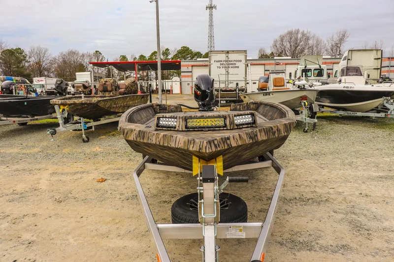 Slide: The Image of 2026 Excel Tomahawk boat on trailer, outdoor display with other boats. - 7