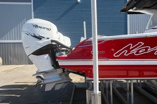 Slide: The Image of 2022 Nor-Tech 452 Super Fish boat on dock, with red and white design, urban backdrop. - 3