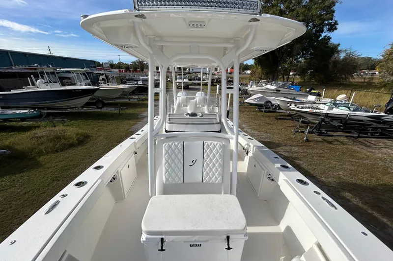 Slide: The Image of 2022 Young Boats 27 model, white interior, parked among other boats outdoors. - 11
