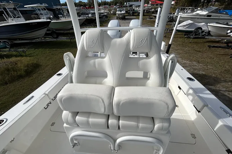 Slide: The Image of 2022 Young Boats 27 model with white cushioned seats, docked among other boats. - 13