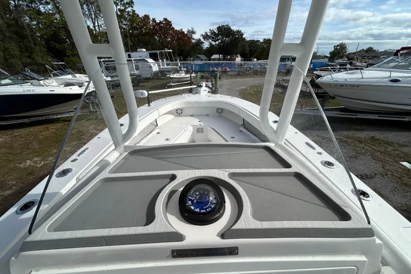 Slide: The Image of 2022 Young Boats 27 model, docked with other boats, featuring a spacious deck. - 16