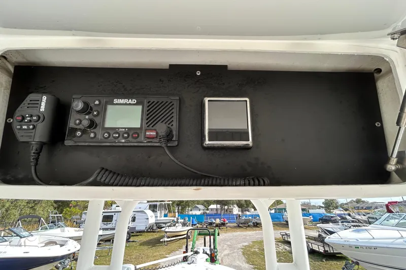 Slide: The Image of 2022 Young Boats 27 dashboard featuring Simrad marine radio and control panel. - 18