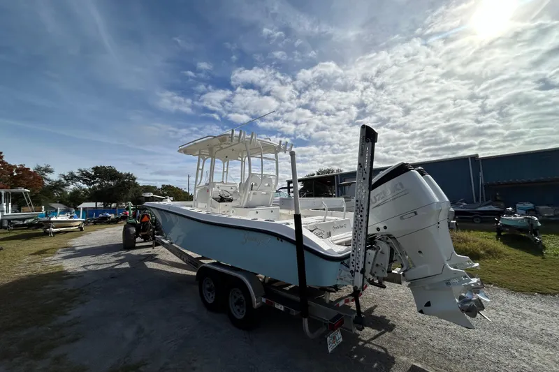 Slide: The Image of 2022 Young Boats 27 on trailer under cloudy sky, parked outdoors. - 4