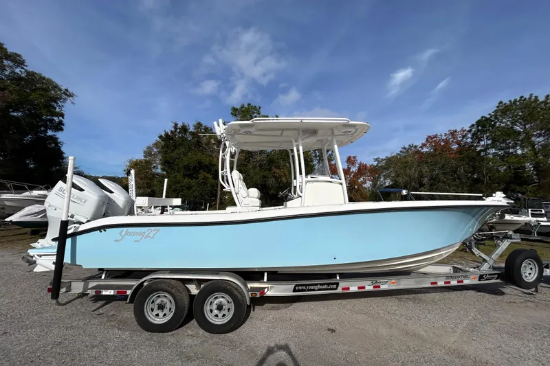 Slide: The Image of 2022 Young Boats 27 on trailer, light blue hull, dual engines, parked outdoors. - 7