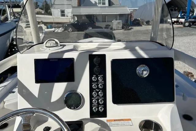 Slide: The Image of 2023 NauticStar 227 XTS boat dashboard with steering wheel and control panel. - 6