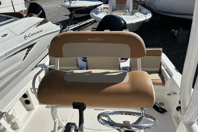 Slide: The Image of 2023 NauticStar 227 XTS boat interior with tan seating and steering wheel. - 7