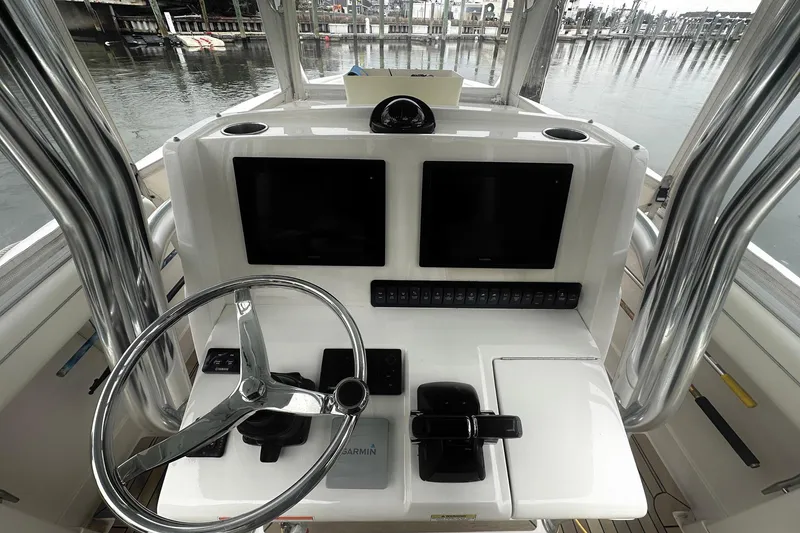 Slide: The Image of 2013 Jupiter 30 Center Console boat helm with dual screens and steering wheel. - 11