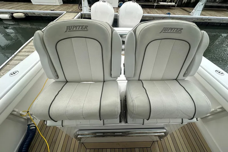 Slide: The Image of 2013 Jupiter 30 Center Console boat seats, white upholstery, docked at marina. - 14