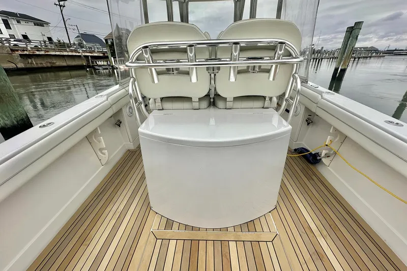 Slide: The Image of 2013 Jupiter 30 Center Console boat interior with sleek seating and wooden deck. - 16