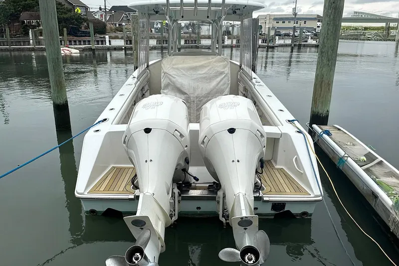 Slide: The Image of 2013 Jupiter 30 Center Console boat with dual outboard engines docked in marina. - 19