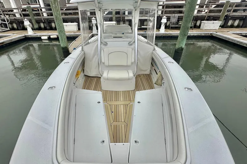 Slide: The Image of 2013 Jupiter 30 Center Console boat docked, featuring spacious seating and sleek design. - 4