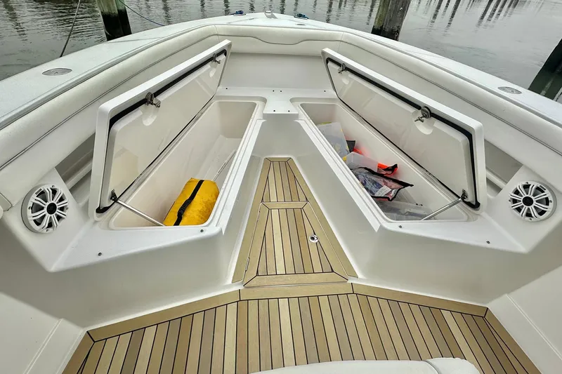 Slide: The Image of 2013 Jupiter 30 Center Console boat with open storage compartments and teak flooring. - 7