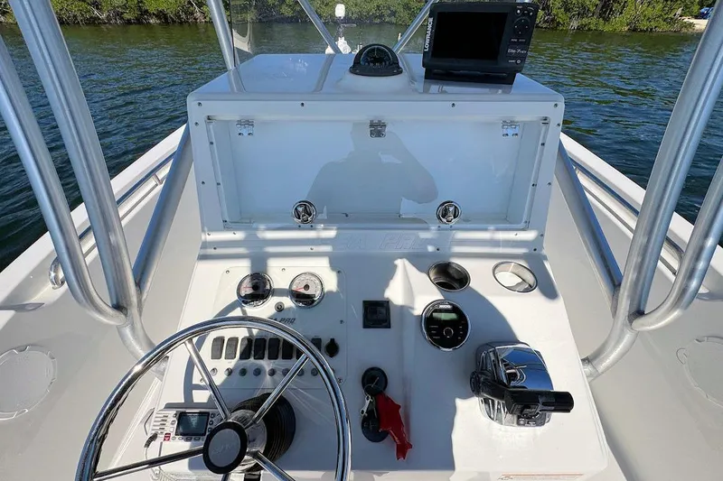 Slide: The Image of 2006 Sea Pro 238 Center Console boat dashboard with steering wheel and navigation equipment. - 9