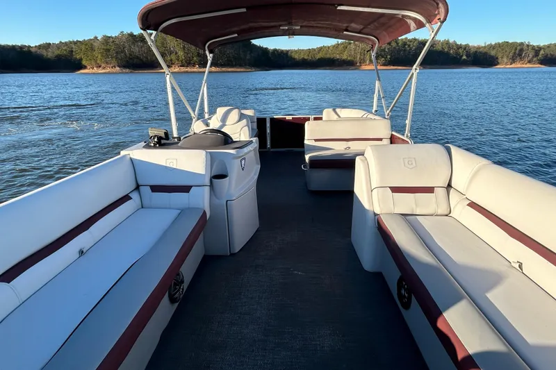 Slide: The Image of 2023 Godfrey Sweetwater 2286 C pontoon boat on a serene lake. - 11
