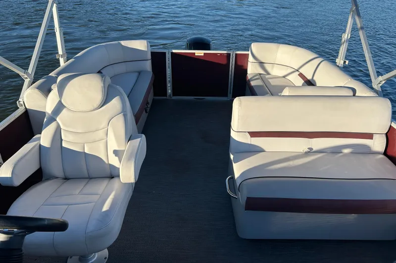 Slide: The Image of 2023 Godfrey Sweetwater 2286 C pontoon boat interior with plush seating on water. - 12