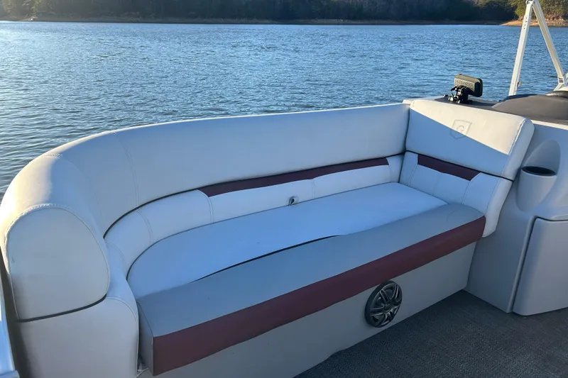 Slide: The Image of 2023 Godfrey Sweetwater 2286 C boat interior with cushioned seating by the water. - 15