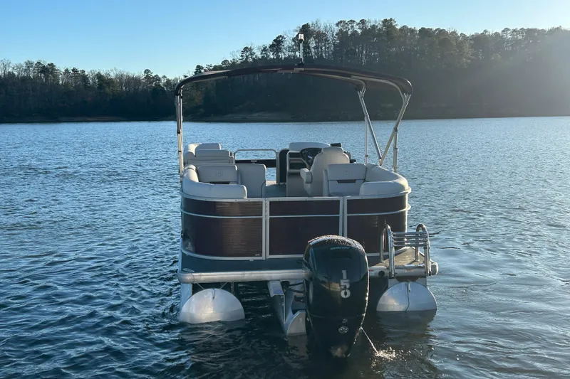 Slide: The Image of 2023 Godfrey Sweetwater 2286 C pontoon boat on a serene lake. - 5