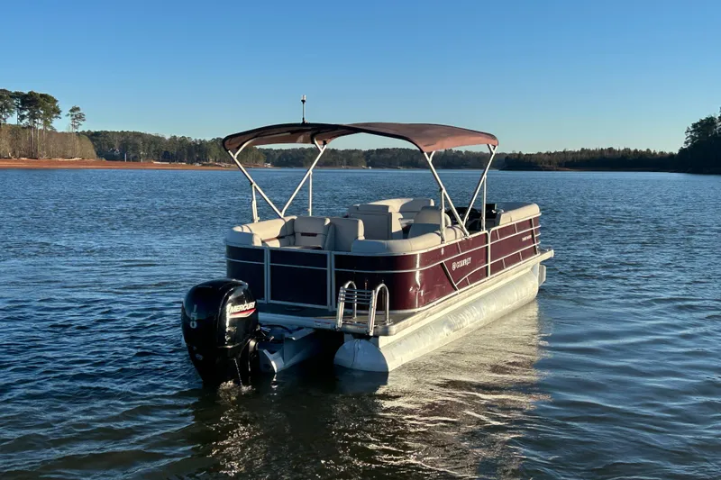 Slide: The Image of 2023 Godfrey Sweetwater 2286 C pontoon boat on a serene lake. - 6