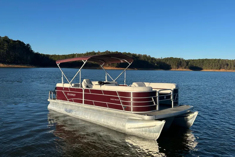 Slide: The Image of 2023 Godfrey Sweetwater 2286 C pontoon boat on a serene lake. - 8