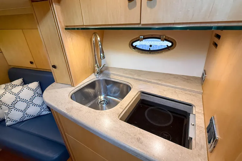 Slide: The Image of 2013 Tiara Yachts 3600 Coronet galley with sink, stove, and porthole window. - 27