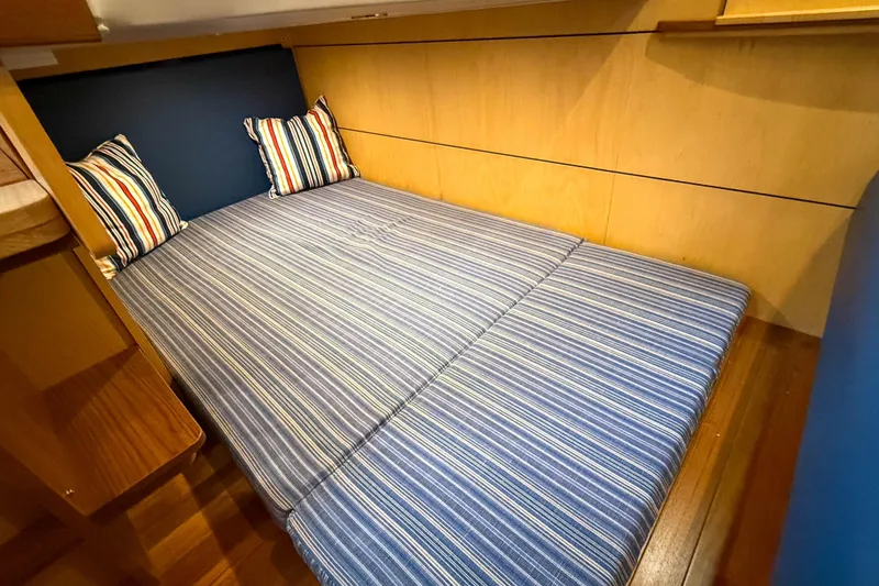Slide: The Image of Cozy cabin interior of 2013 Tiara Yachts 3600 Coronet with striped bedding and pillows. - 31
