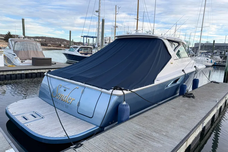 Slide: The Image of 2013 Tiara Yachts 3600 Coronet docked, covered, with blue fenders, in a marina setting. - 47